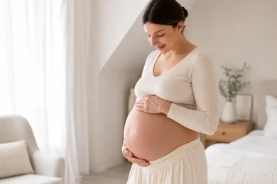 Pregnant woman in a bright bedroom representing surrogate requirements and qualification standards for Global Surrogacy Services.